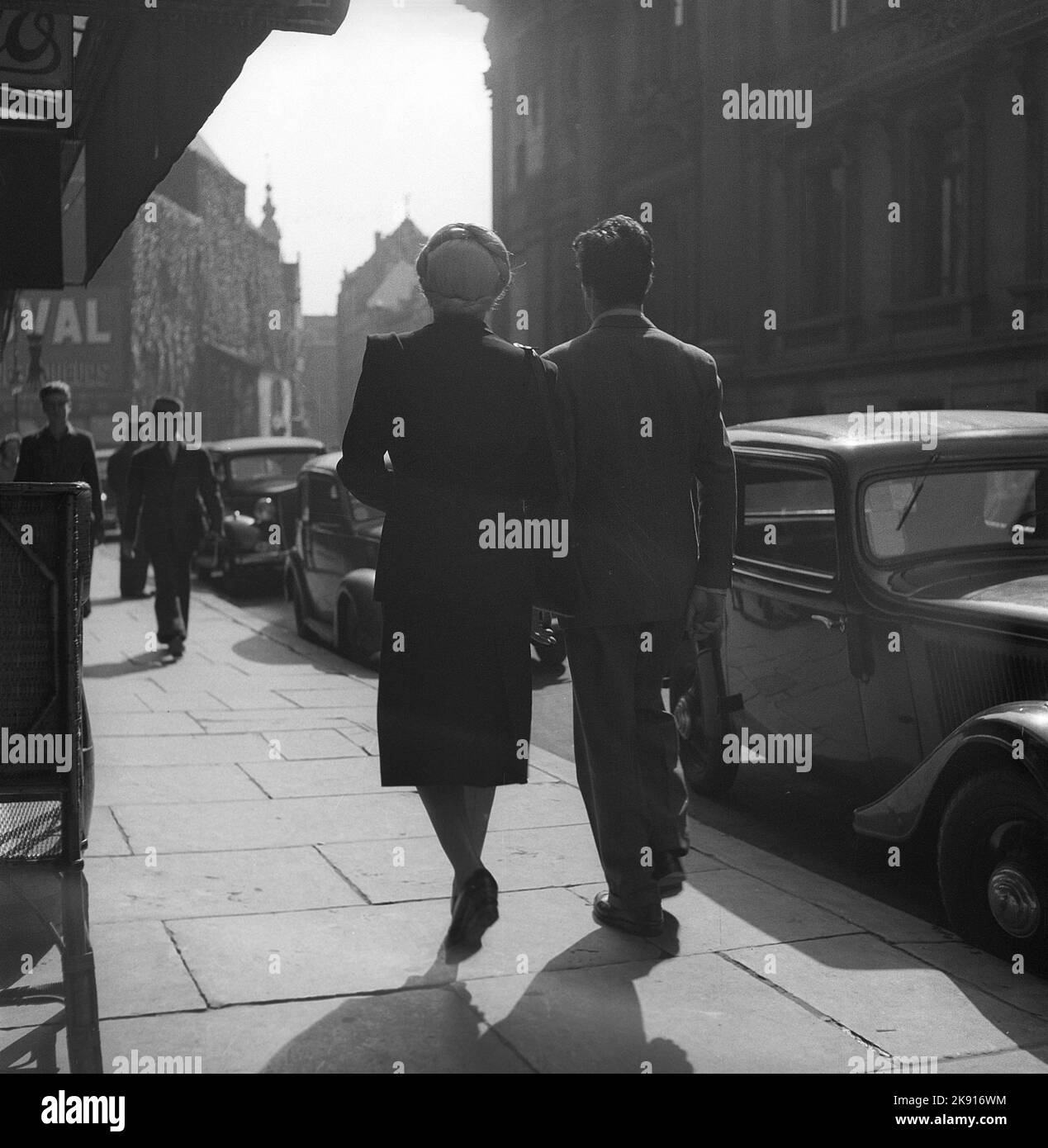 1940s couple. A man and a woman are seen from behind walking in a Brussel street. Brusells Belgium 1946. Kristoffersson V144-4 Stock Photo