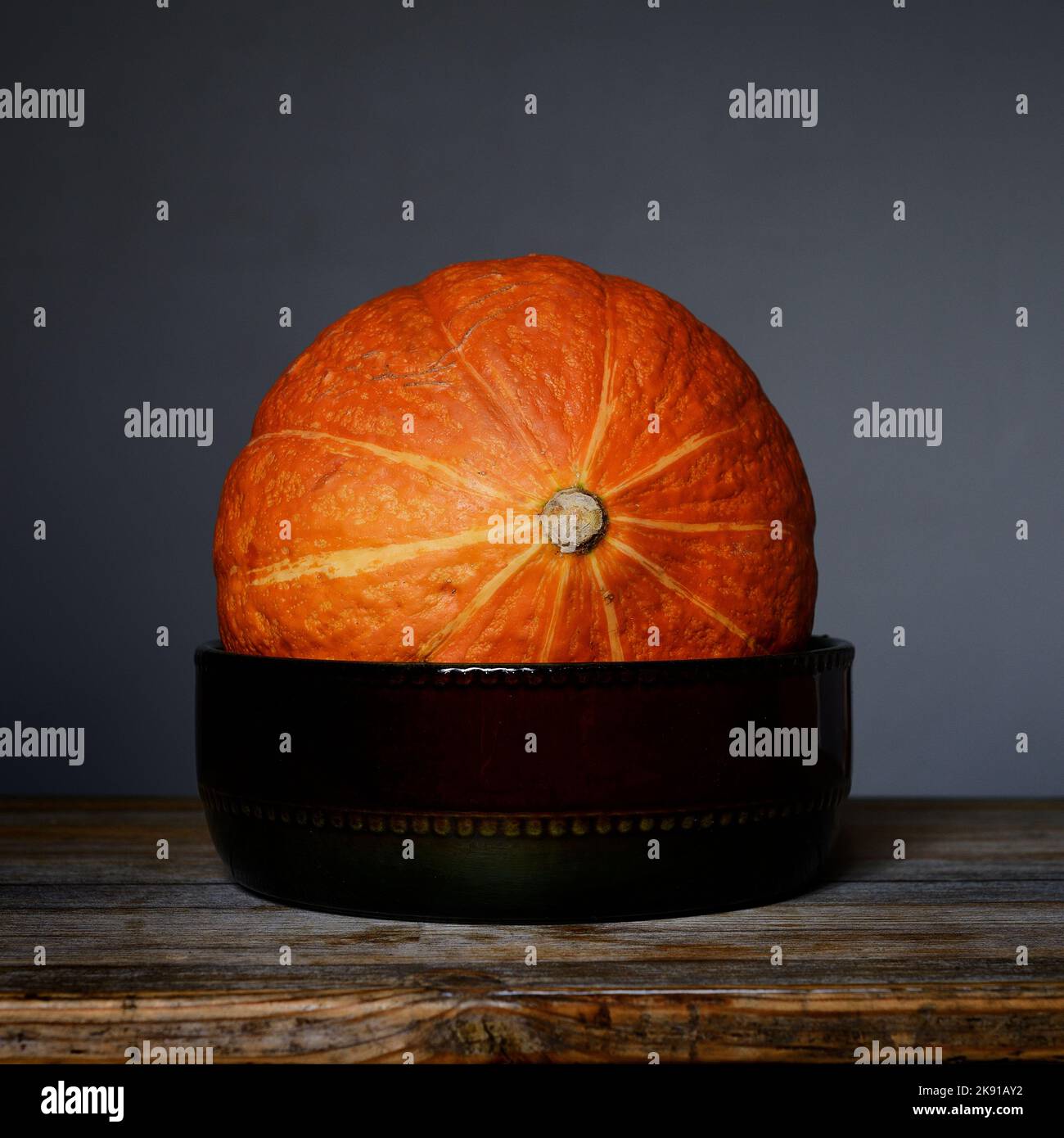 bright orange Hokkaido pumpkin in a ceramic bowl Stock Photo
