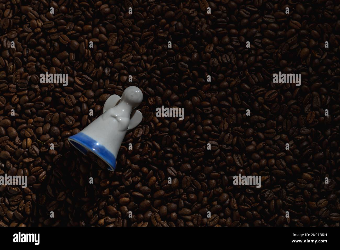 Figurine of an angel on a background of coffee beans Stock Photo