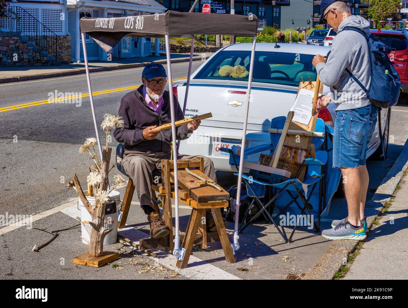 Plymouth, Massachusetts, USA - September 12, 2022: A street vender sets up shop behind a parked car selling his hand carved wood items.. Stock Photo