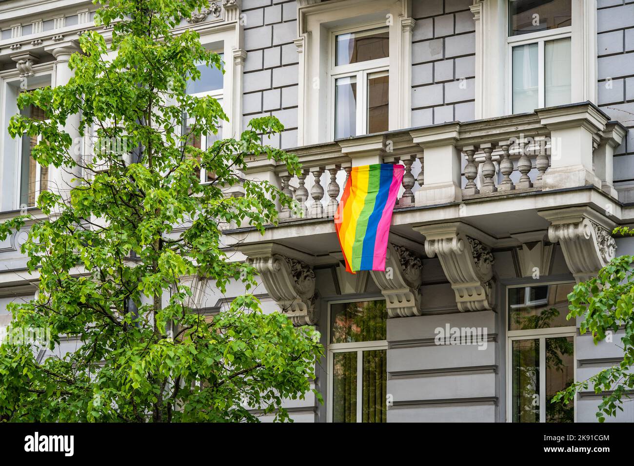 Rainbow LGBT flag hanging on the balcony of a residential building in Vilnius Stock Photo