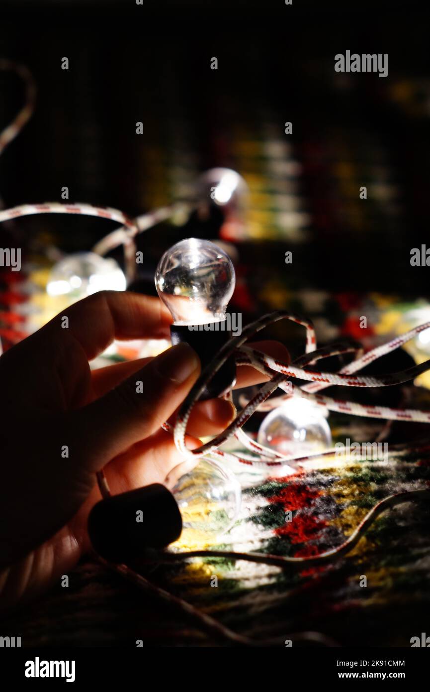 Christmas light in child hand. Electric Christmas light in dark room