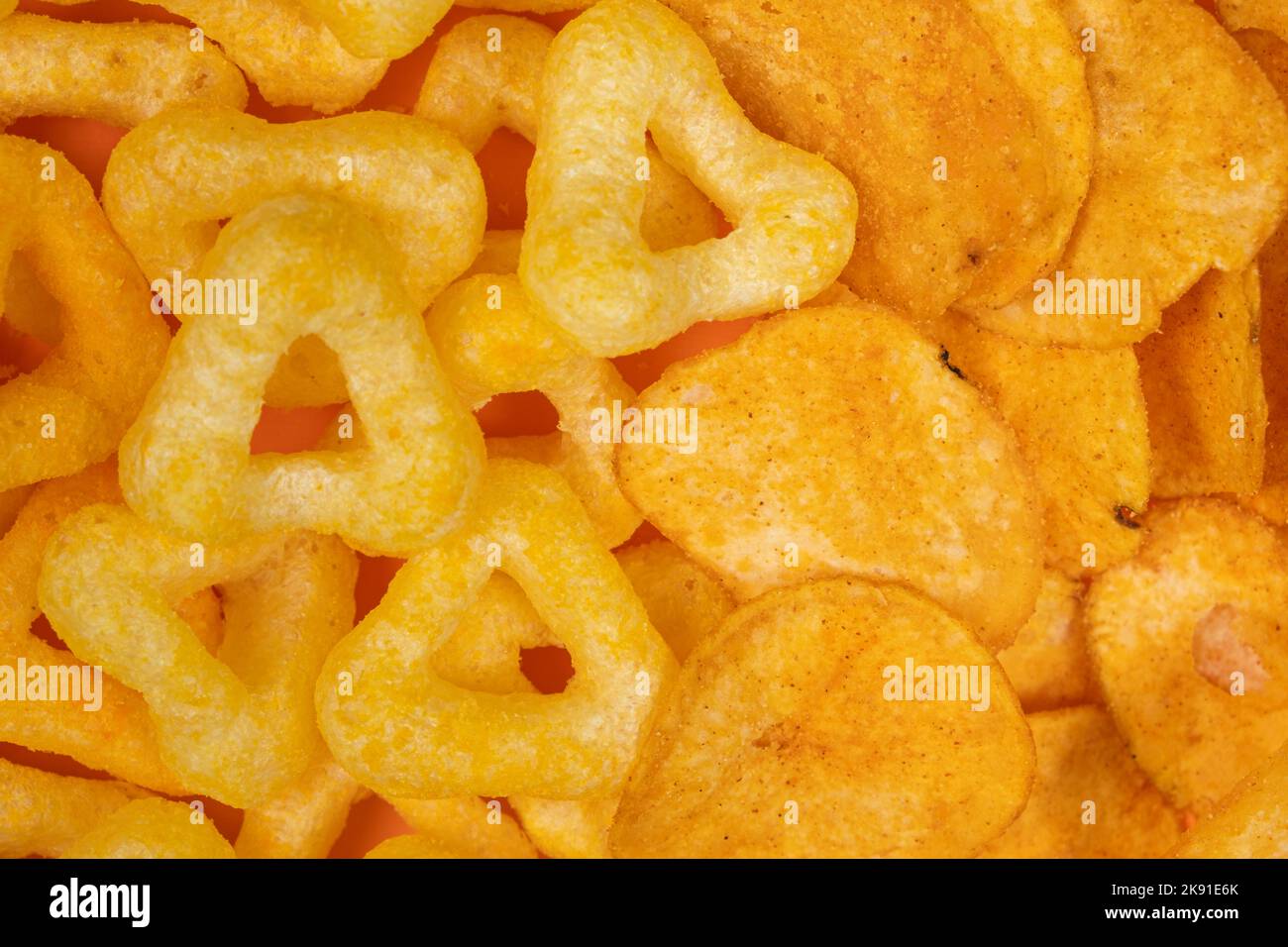 Crispy potato and corn chips, close-up view from above. Stock Photo
