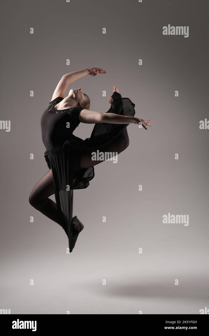 Ballerina Dancing with Silk Fabric, Modern Ballet Dancer in Fluttering Waving Cloth, Gray Background Stock Photo