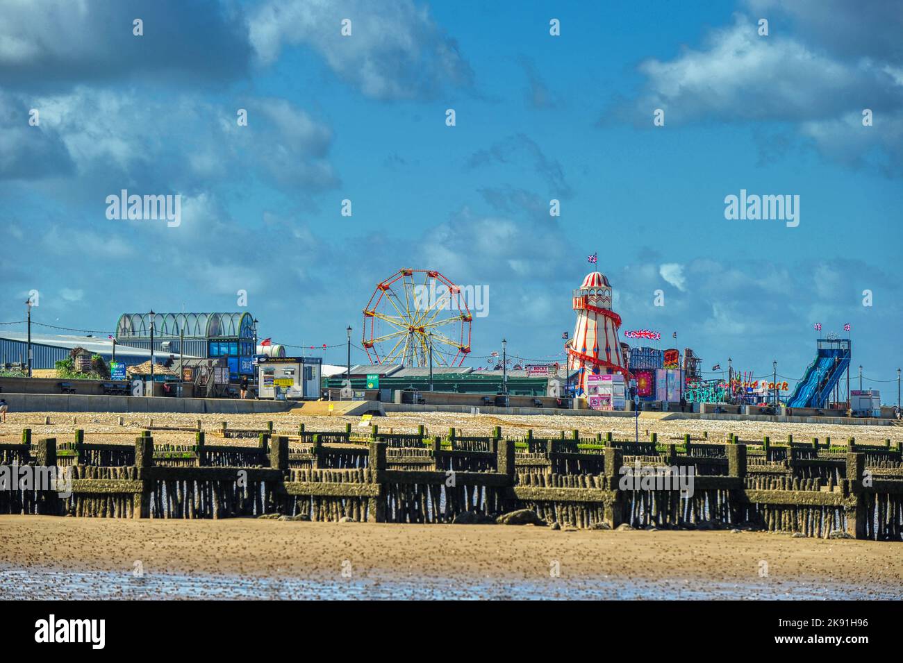 Rainbow Park Amusements fair at Hunstanton in Norfolk seen across the beach at low tide the beach Stock Photo