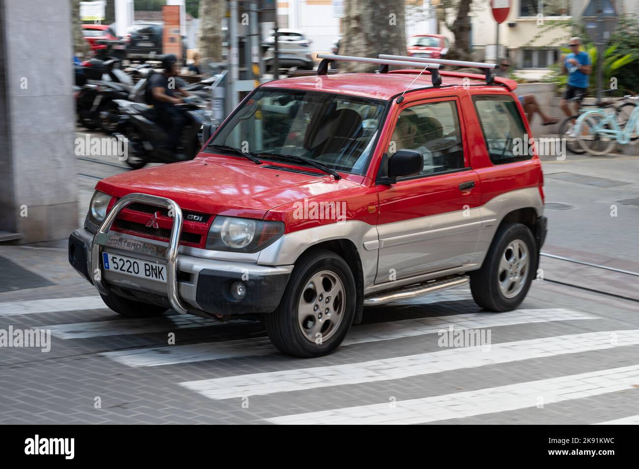 A red Mitsubishi Pajero Montero SUV with a tubular front bumper in