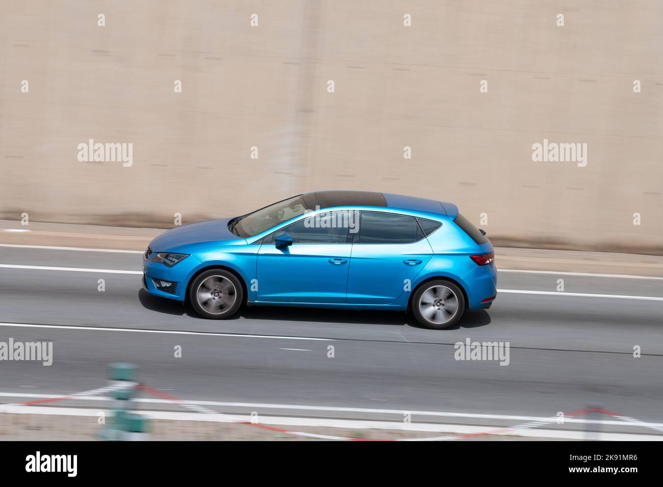 A tourism brand Seat Leon of blue color circulating around the round along Barcelona's Ronda Litoral Stock Photo