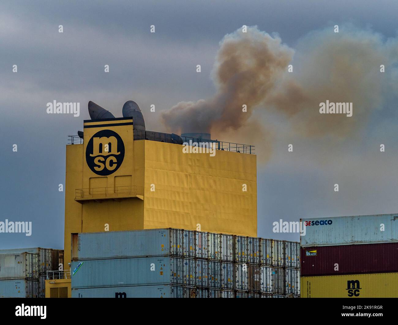 Ship exhaust emissions - Ship Funnel smoke - Ship funnel exhaust - Pollution from Ships - engine smoke from an MSC container ship Stock Photo