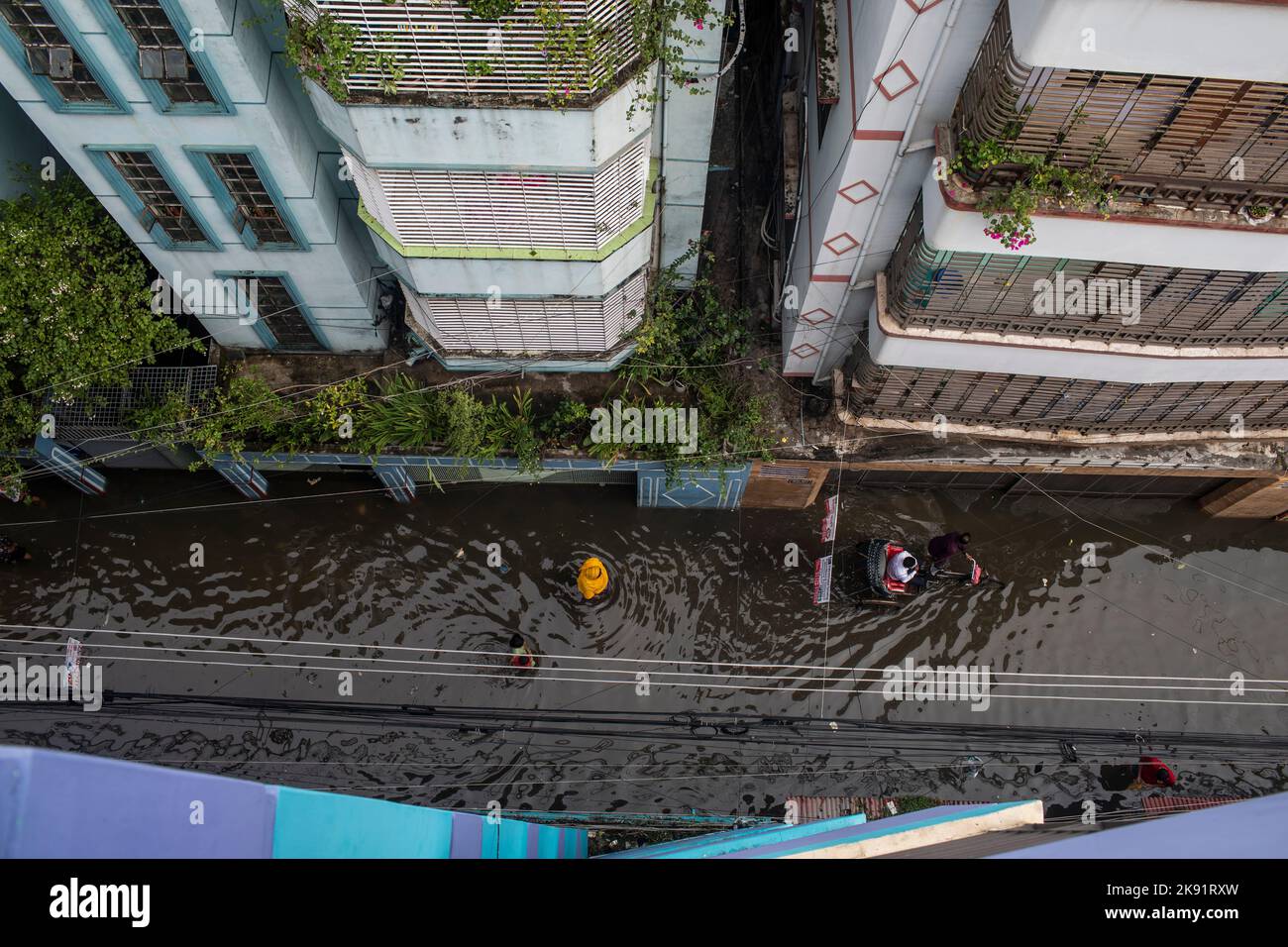 Dhaka, Bangladesh. 25th Oct, 2022. People wade through a waterlogged