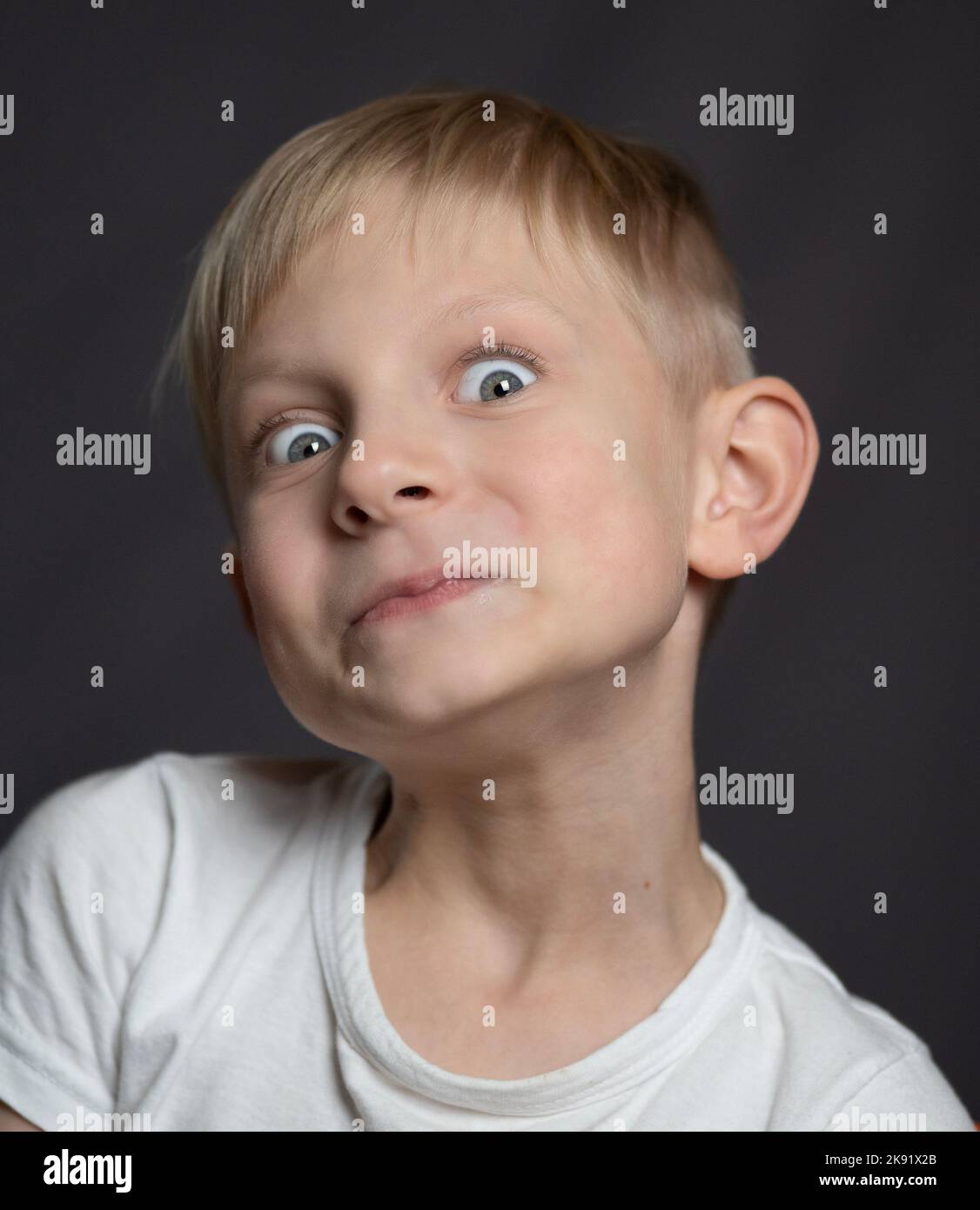 Studio portrait of a blue-eyed blonde caucasian boy making faces Stock ...