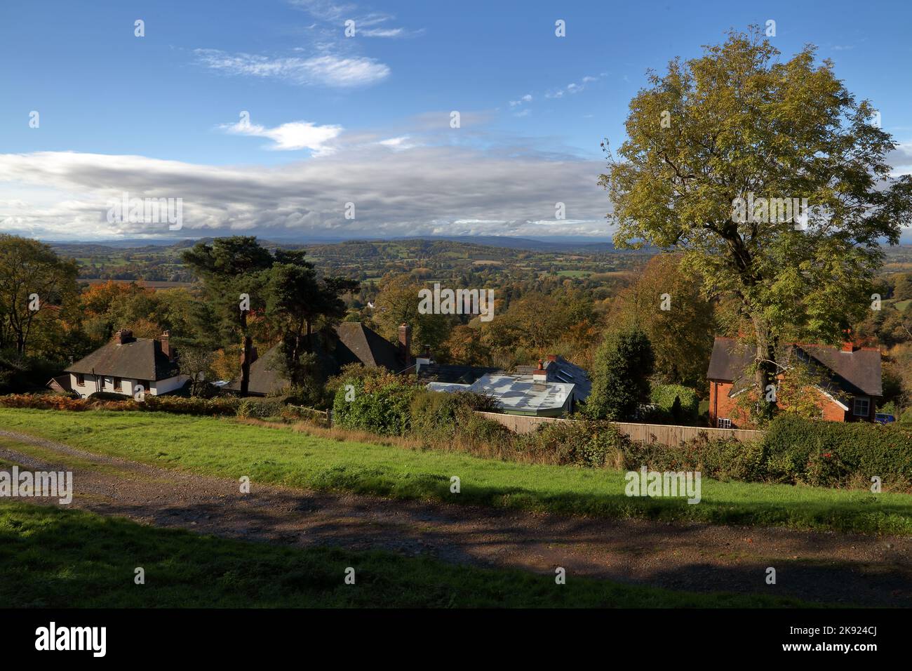 Looking out across the landscape from halfway up a Malvern hill showing a few houses and woods along with fields as far as the eye can see. Stock Photo