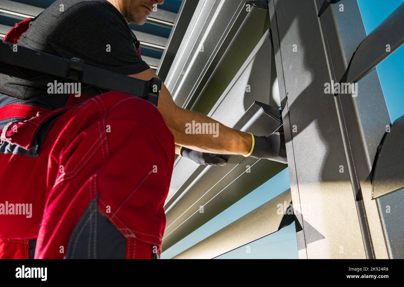 Caucasian Worker Checking and Fixing Aluminum Patio Blinds in His Client's Backyard. Residential