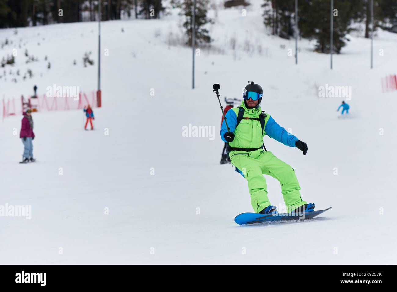 Male snowboarder riding with action camera. Stock Photo