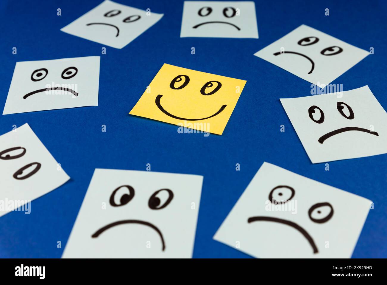 Sticky notes with hand drawn Smiley face and Sad faces on blue ...