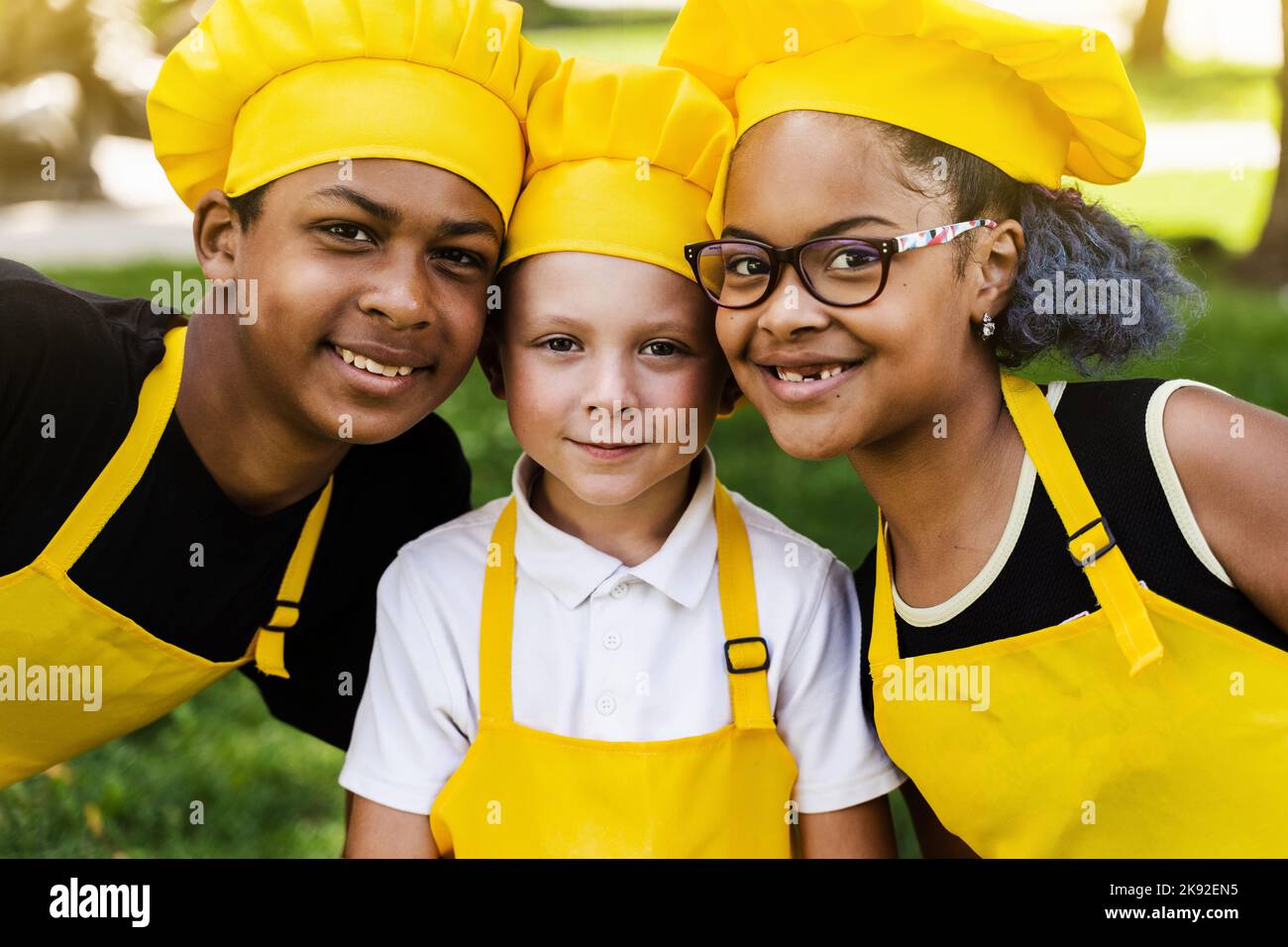 African children cooks in chefs hat and yellow uniforms grimacing and  showing tongue each others. African teenager and black girl have fun and  cook fo Stock Photo - Alamy