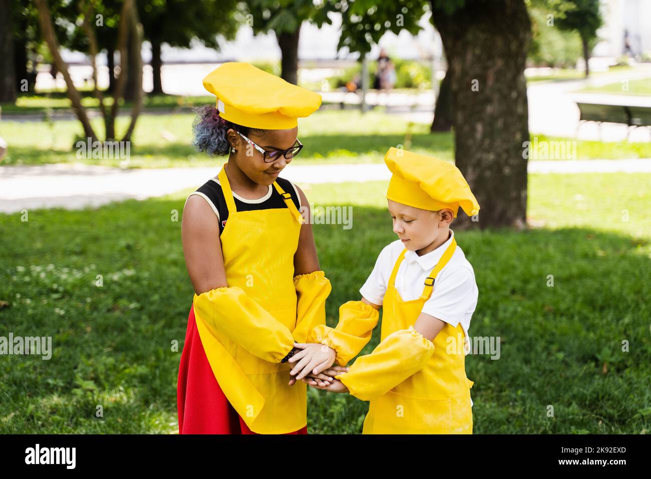 Communication between multiracial friends of black african and caucasian cook children in yellow
