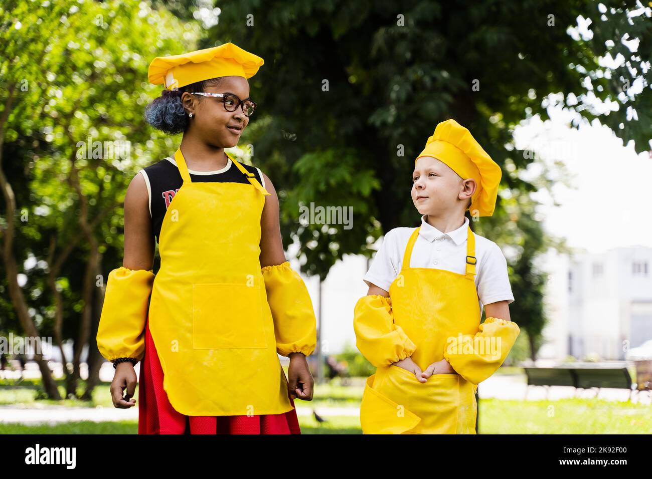 Communication between multiracial friends of black african and caucasian cook children in yellow