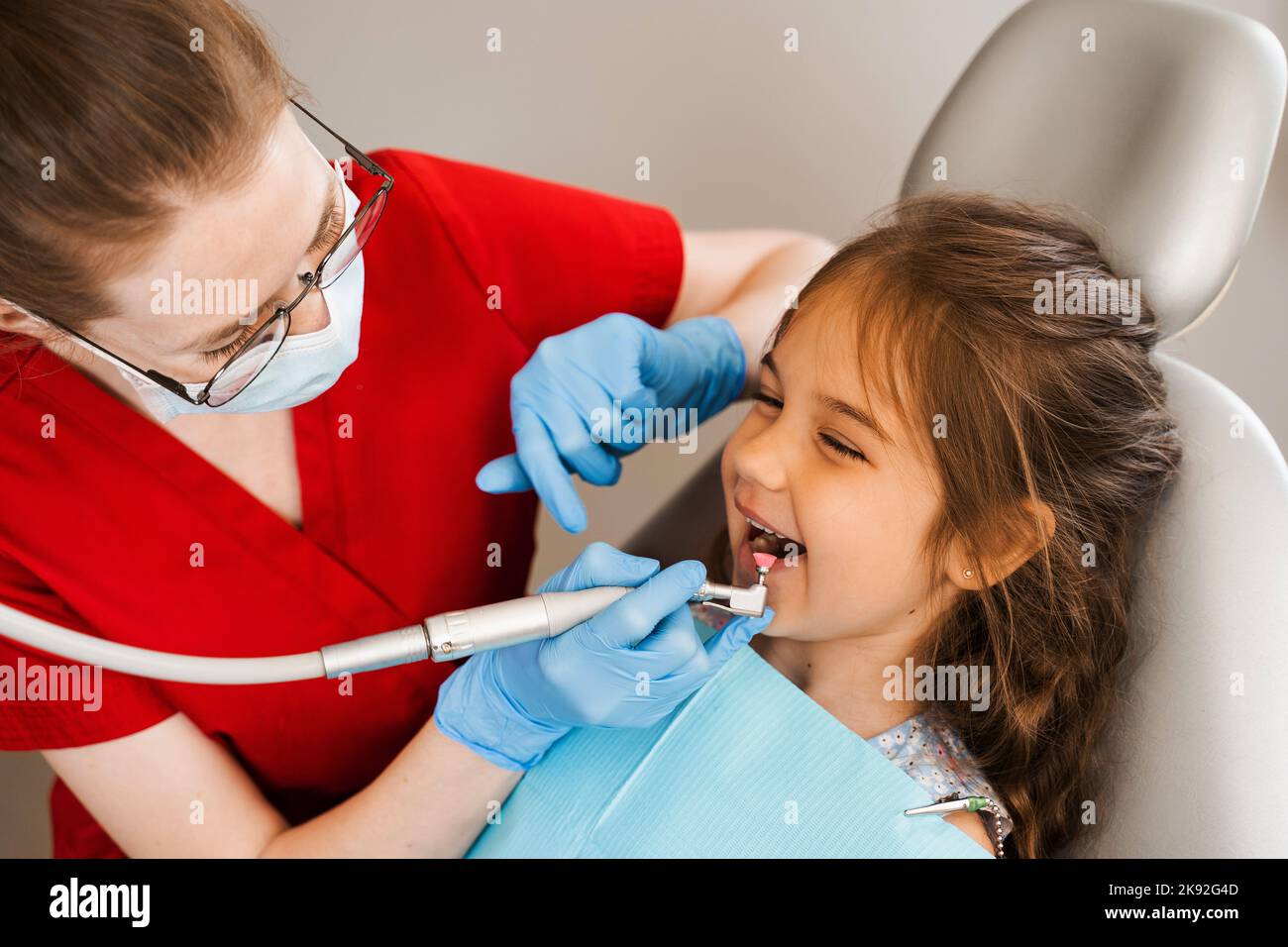 Child dentist makes professional teeth cleaning in dentistry