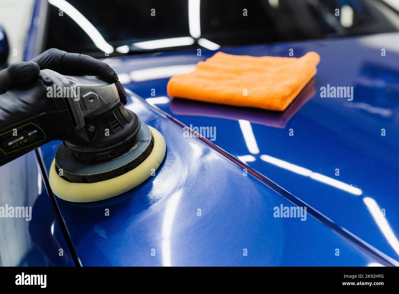Car polishing with orbital polisher for remove scratches. Worker of detailing auto service