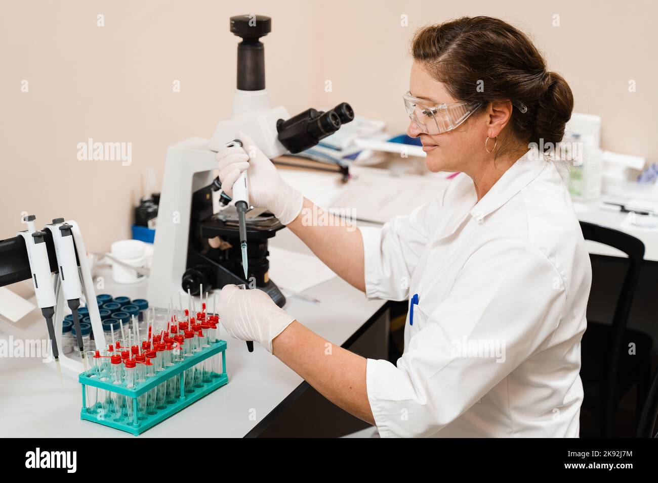 Laboratory assistant with microdoser in laboratory doing blood test