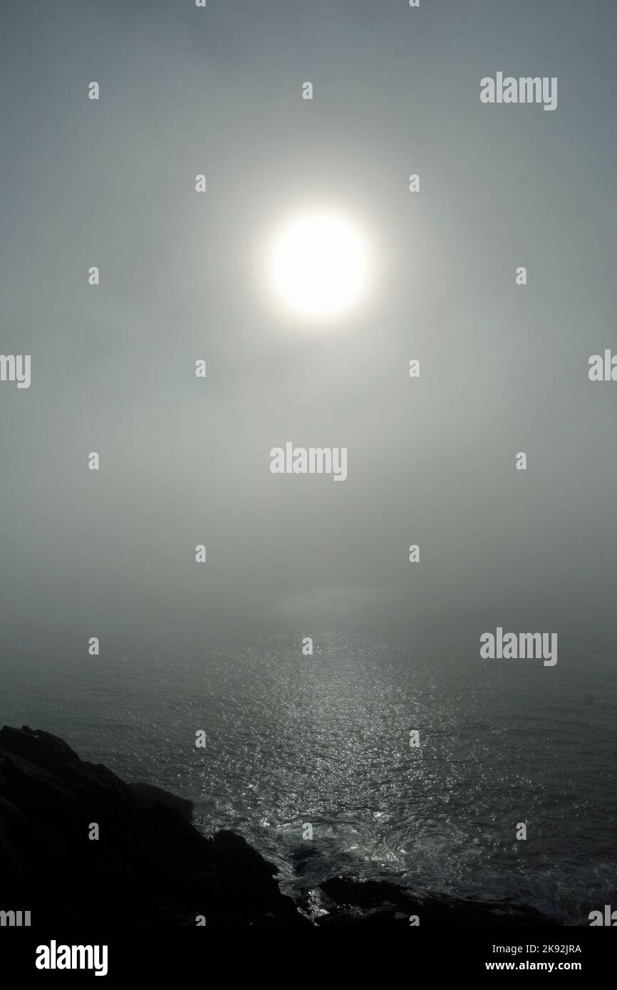 sun shining through sea fog Stock Photo