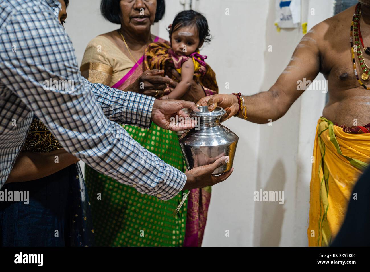 A pandit passes over a milk pot that was used to bathe milk onto a