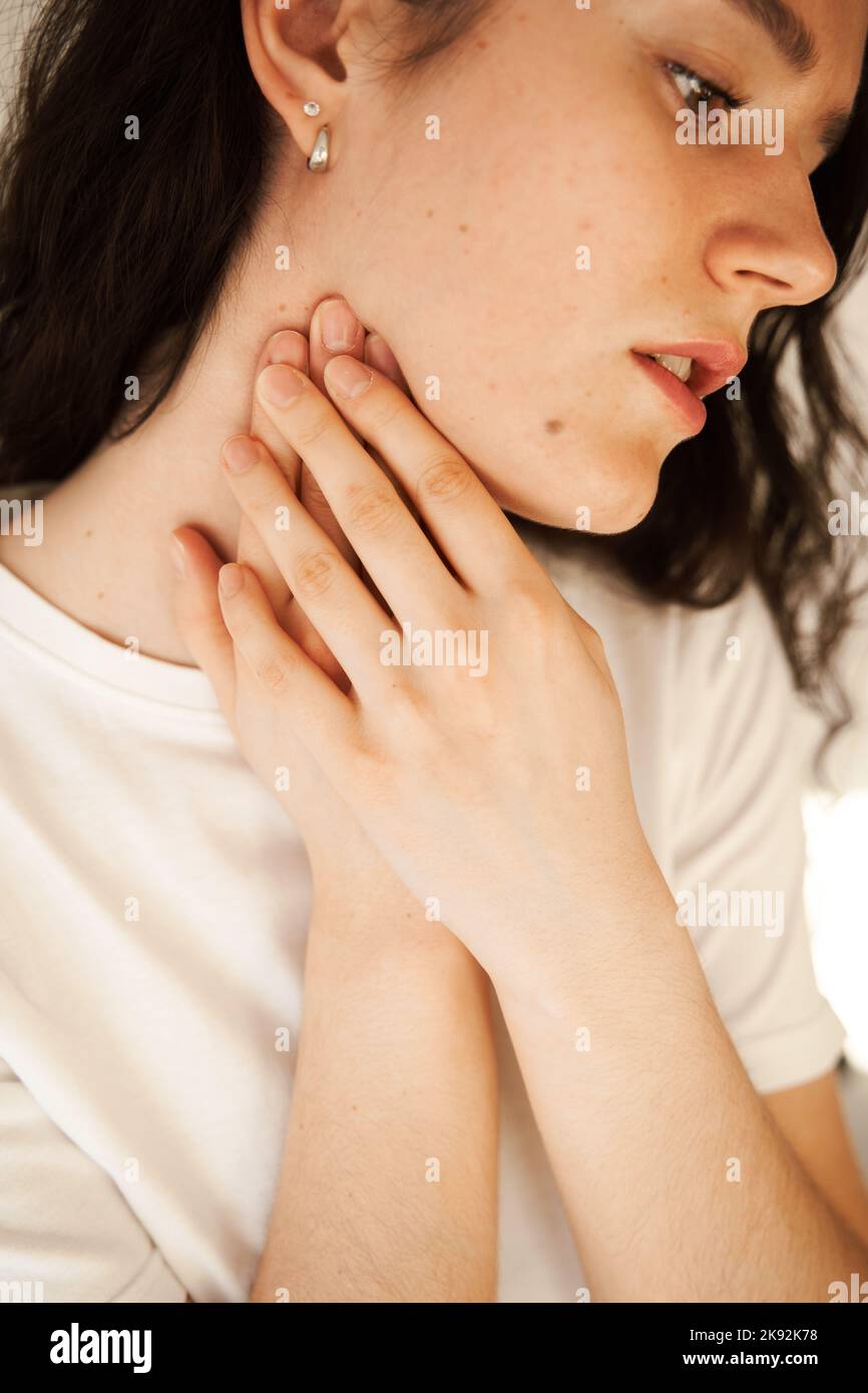 Sick attractive girl touches throat with pain. Laryngitis first