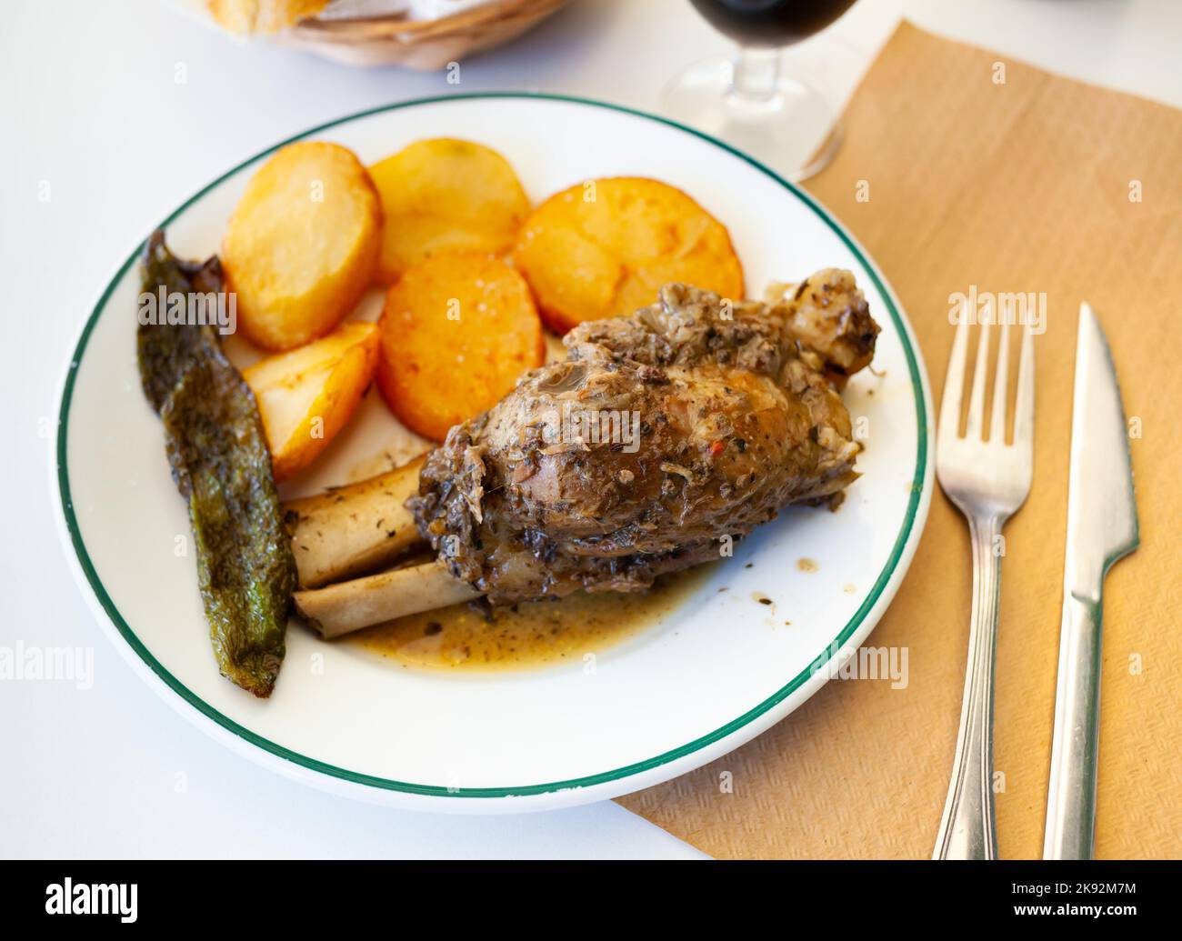 Braised pork knuckle with fried potatoes and baked pepper Stock Photo