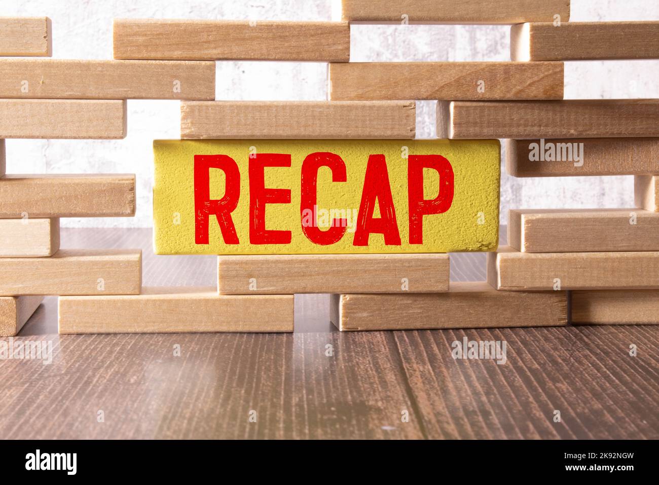 The text recap appearing behind torn yellow paper. Stock Photo