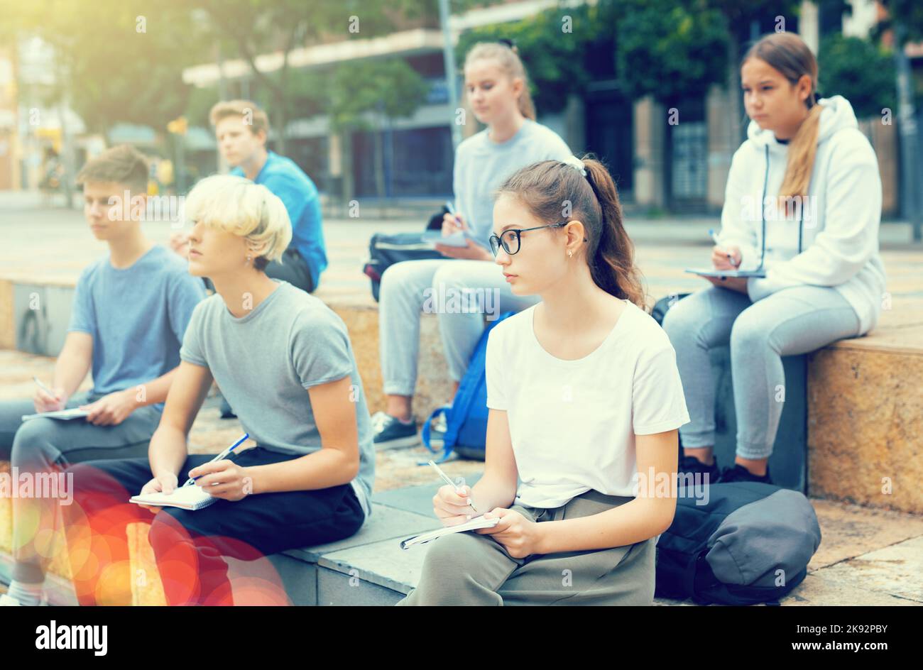Focused teen students during lesson outside school Stock Photo