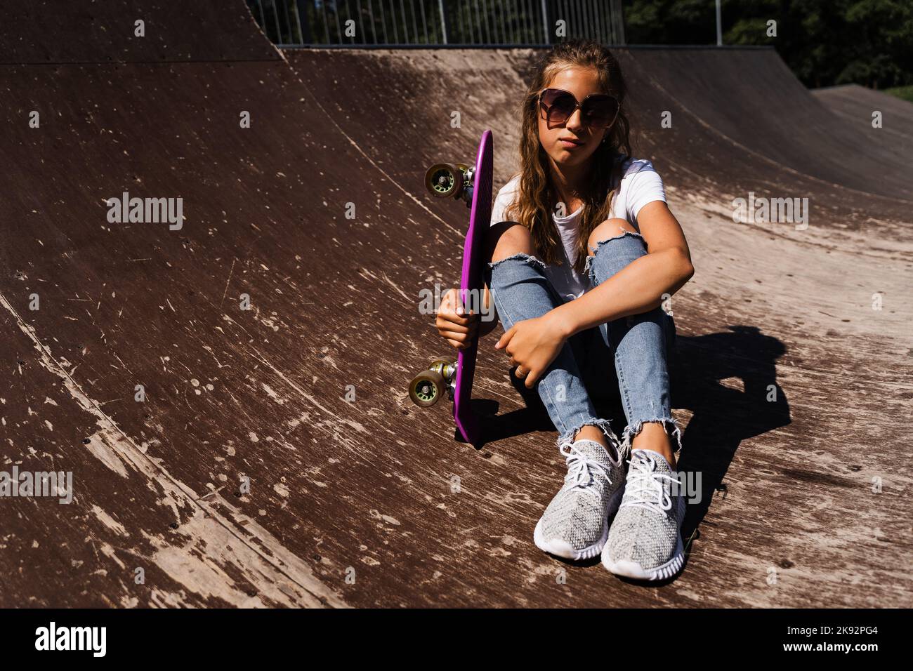 child-model-in-glasses-sitting-and-posing-with-penny-board-on-skate