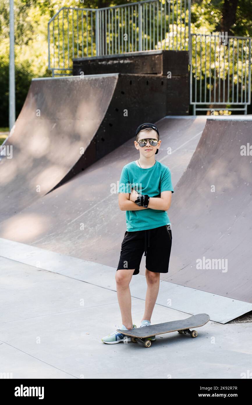 Happy young child boy with skate board on playground and smile. Extreme ...
