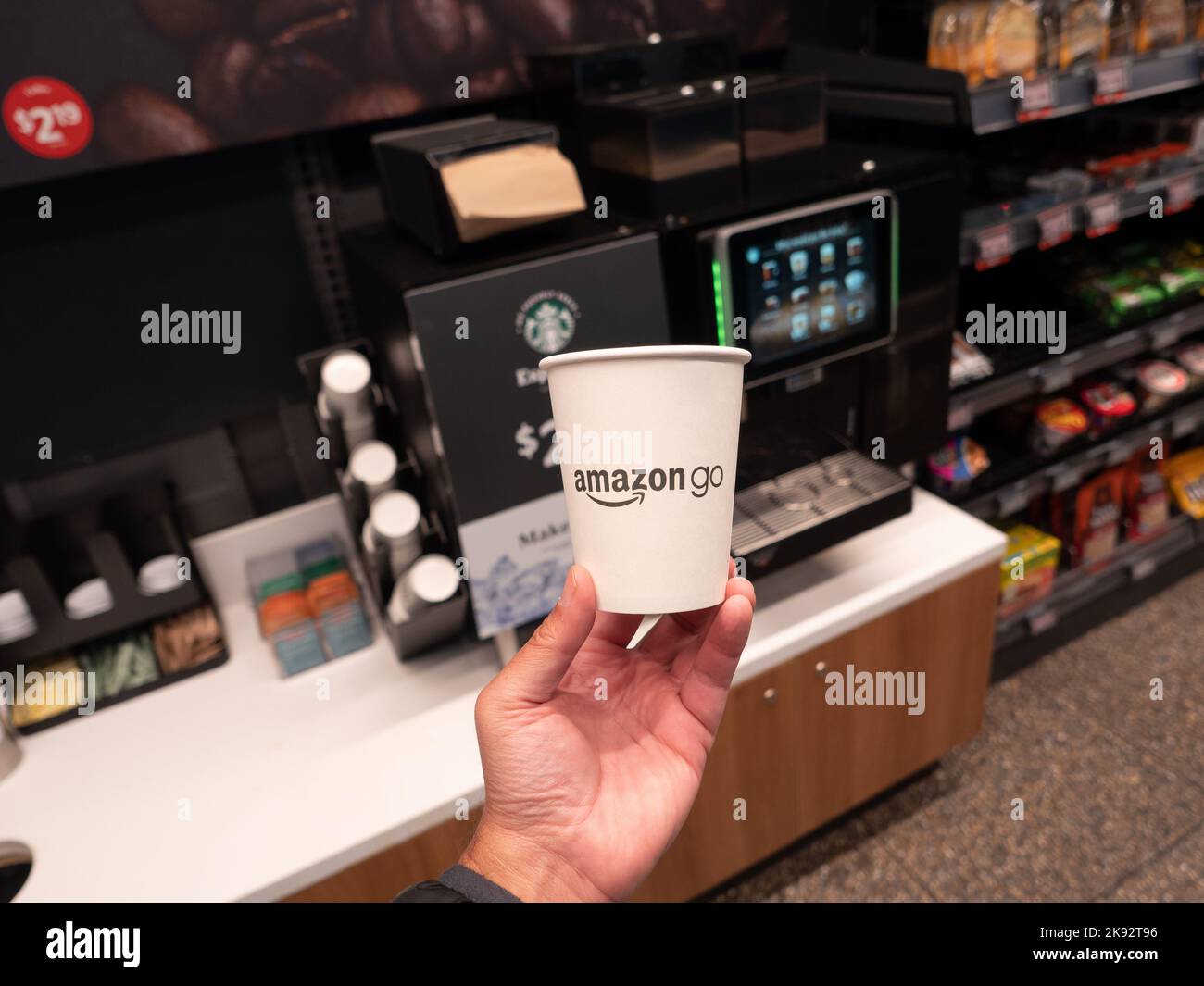 A coffee cup next to an automated Starbucks machine at the Amazon Go
