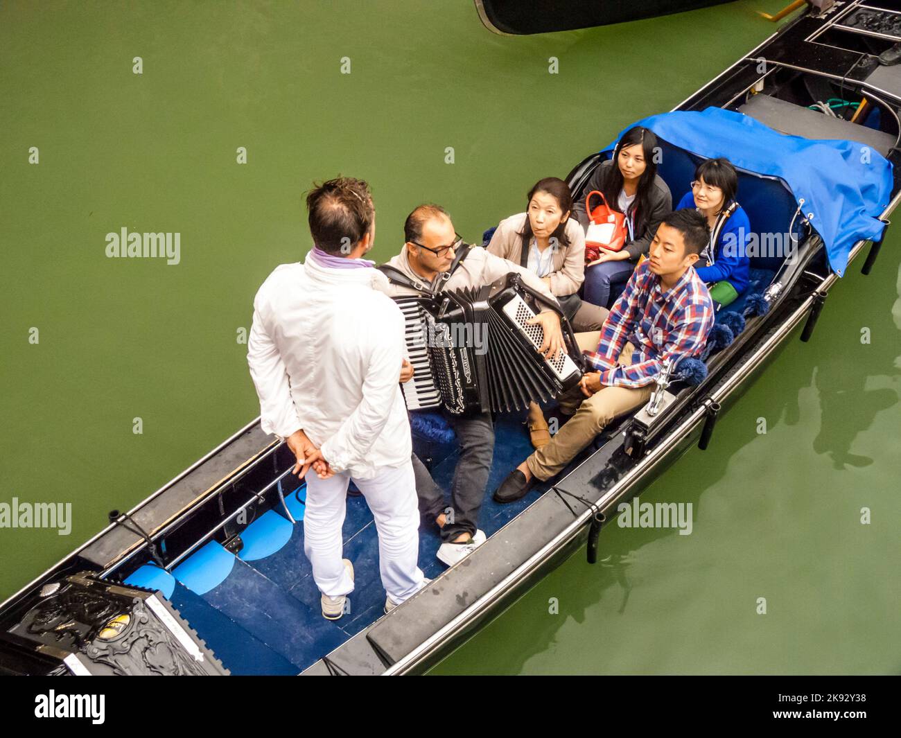 VENICE, ITALY - SEP 12, 2014: Venetian gondolas with tourist sail in the canal in Venice. Permissions for gondolas are very expensive and limited. Stock Photo