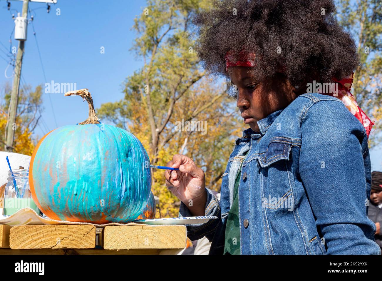 Detroit, Michigan - A girl paints a pumpking at a fall festival in Detroit's Morningside neighborhood. The event was organized by the Motor City Groun Stock Photo