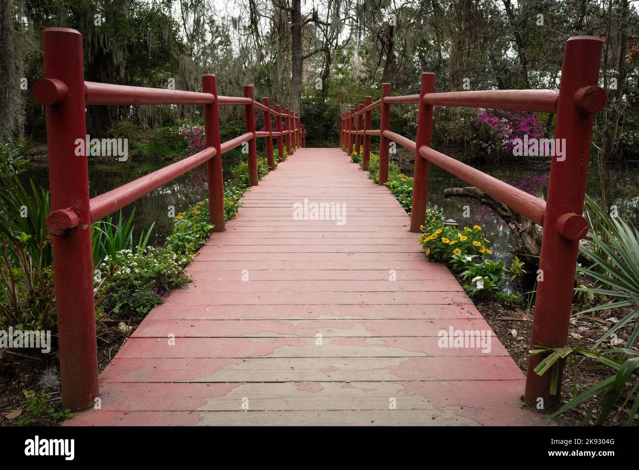 Red foot bridge spanning a swamp Stock Photo