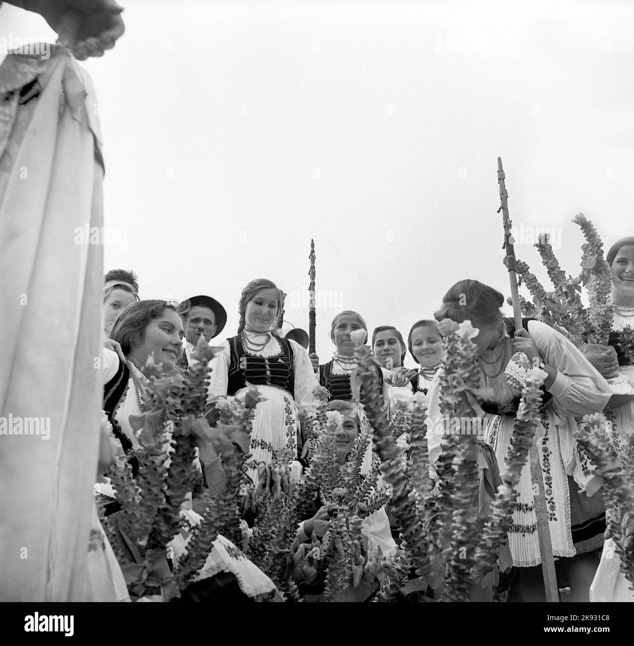 Covasna County, Romania, approx. 1974. Hungarian ethnics wearing their folk costumes celebrating 'Farsang' with the traditional doughnuts. Stock Photo