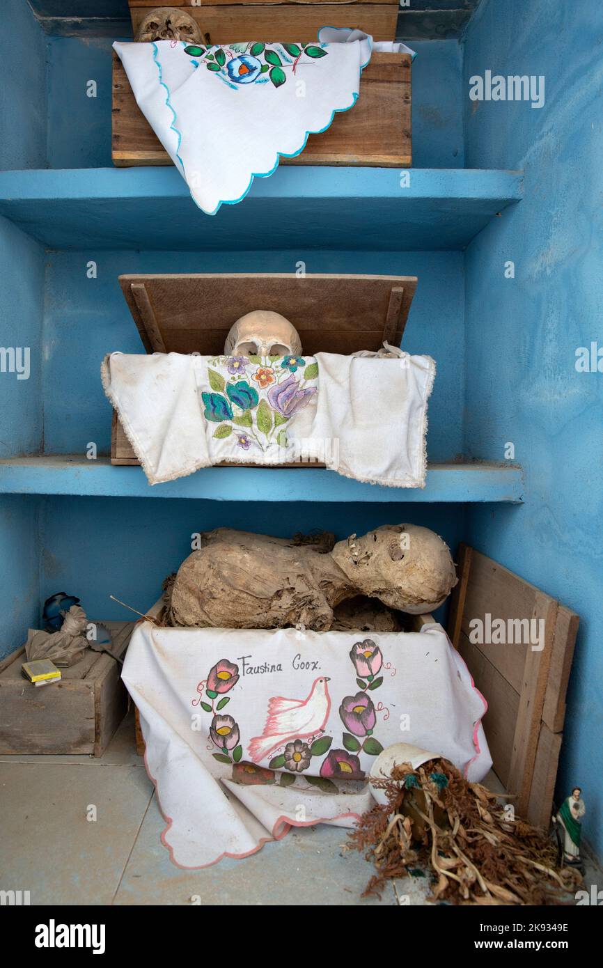 Dried-up skulls and bones are seen wrapped in embroidered white tablecloths bearing the names of the deceased, and placed in wooden crates inside a niche at the cemetery in Pomuch, Campeche state, Mexico on October 22, 2022. Every year in preparation for Hanal Pixán, the Mayan Day of the Dead celebration, members of the Pomuch community in southeastern Mexico extract bones from their niches and carefully clean them – an ancestral tradition seen as a gesture of love and a way to get closer to deceased family members. This ritual, which in Mayan is known as Choo Ba’ak, can be done for the first Stock Photo