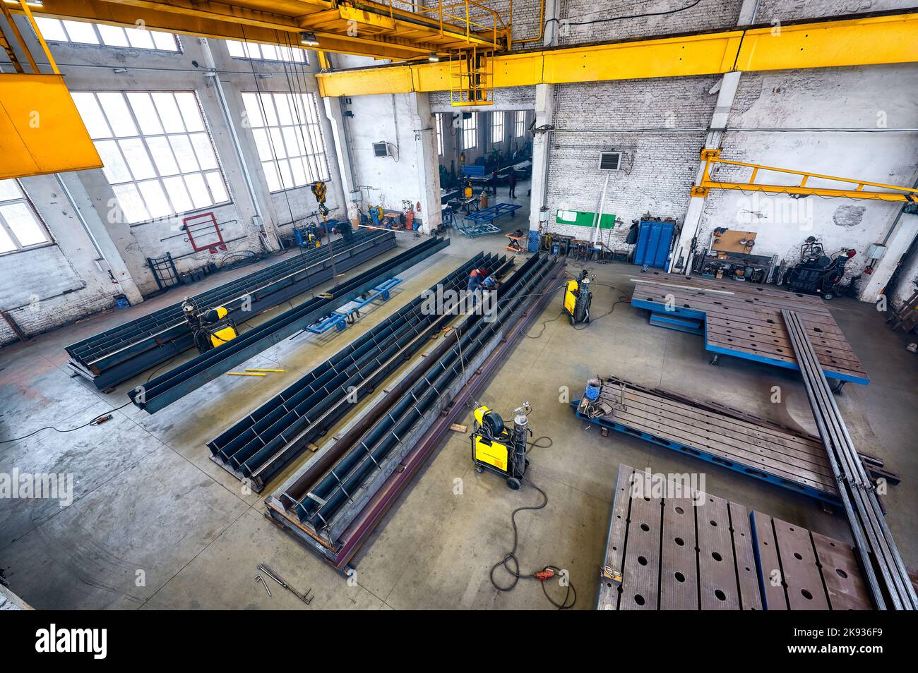Long steel constructions assembling with welding in workshop Stock Photo
