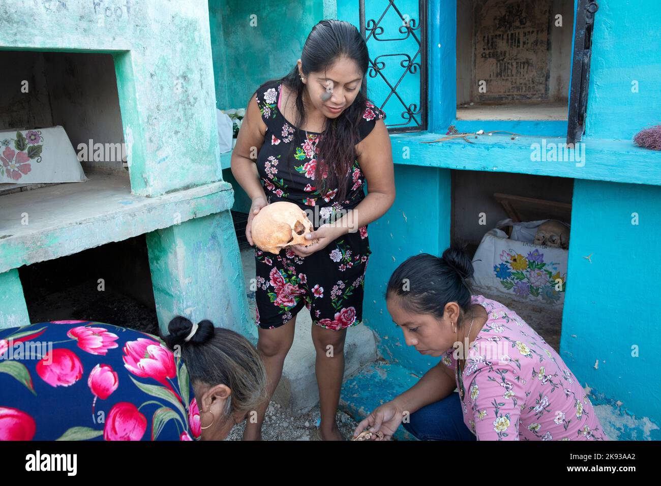 Women clean the bones and skulls of their deceased relatives from the Uitz Poot family at the cemetery of Pomuch, Campeche state, Mexico on October 22, 2022. Every year in preparation for Hanal Pixán, the Mayan Day of the Dead celebration, members of the Pomuch community in southeastern Mexico extract bones from their niches and carefully clean them – an ancestral tradition seen as a gesture of love and a way to get closer to deceased family members. This ritual, which in Mayan is known as Choo Ba’ak, can be done for the first time when a person has been dead for three years. Pomuch and a hand Stock Photo