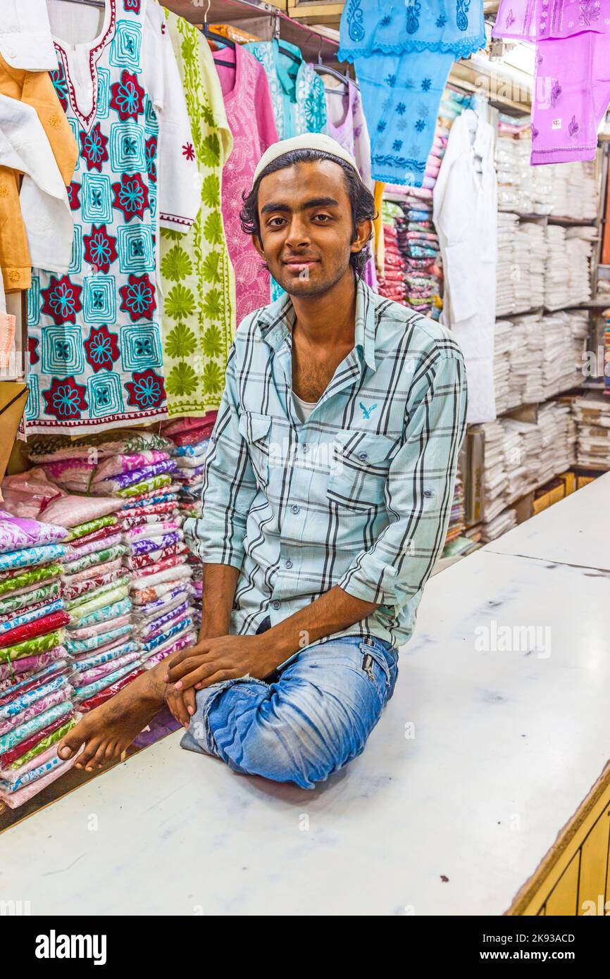 DELHI - NOVEMBER 10, 2011: shop owner indian man selling shawls and clothing at his store   in Delhi, India. Shah Jahan founded the bazaar in the 17th Stock Photo