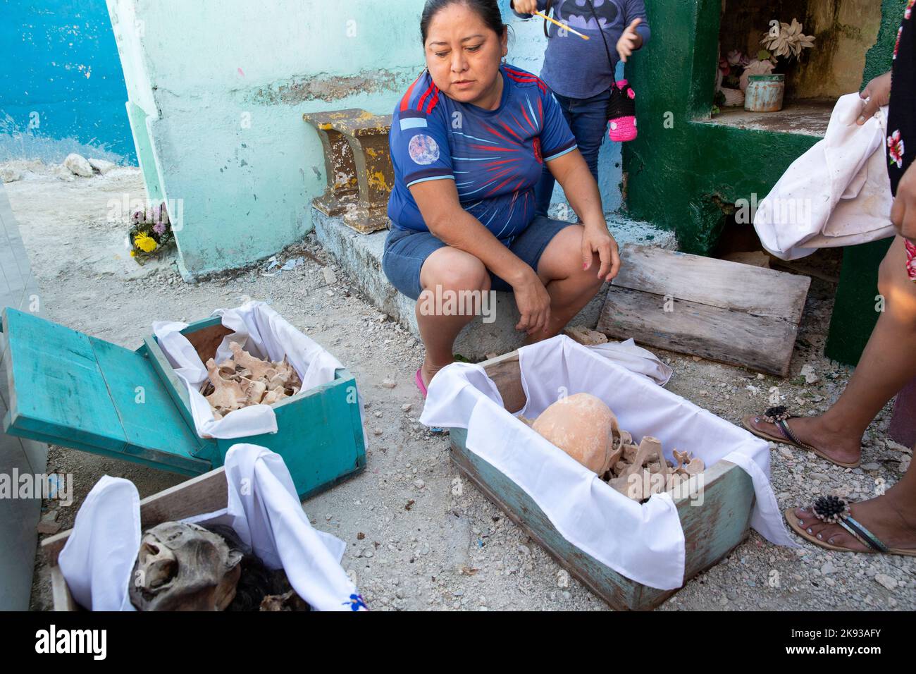 Women clean the bones and skulls of their deceased relatives from the Kuk Pech family at the cemetery of Pomuch, Campeche state, Mexico on October 22, 2022. Every year in preparation for Hanal Pixán, the Mayan Day of the Dead celebration, members of the Pomuch community in southeastern Mexico extract bones from their niches and carefully clean them – an ancestral tradition seen as a gesture of love and a way to get closer to deceased family members. This ritual, which in Mayan is known as Choo Ba’ak, can be done for the first time when a person has been dead for three years. Pomuch and a handf Stock Photo