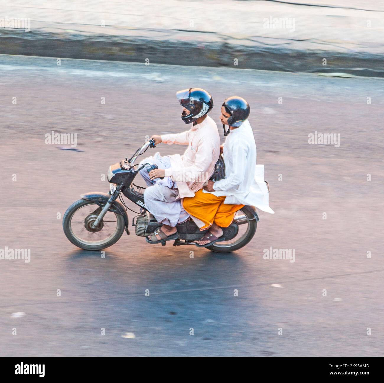 JAIPUR, INDIA - NOV 13, 2011: Two men riding on a bike (blurred motion). Motorbike is the most favorite vehicle and most affordable for India. Stock Photo