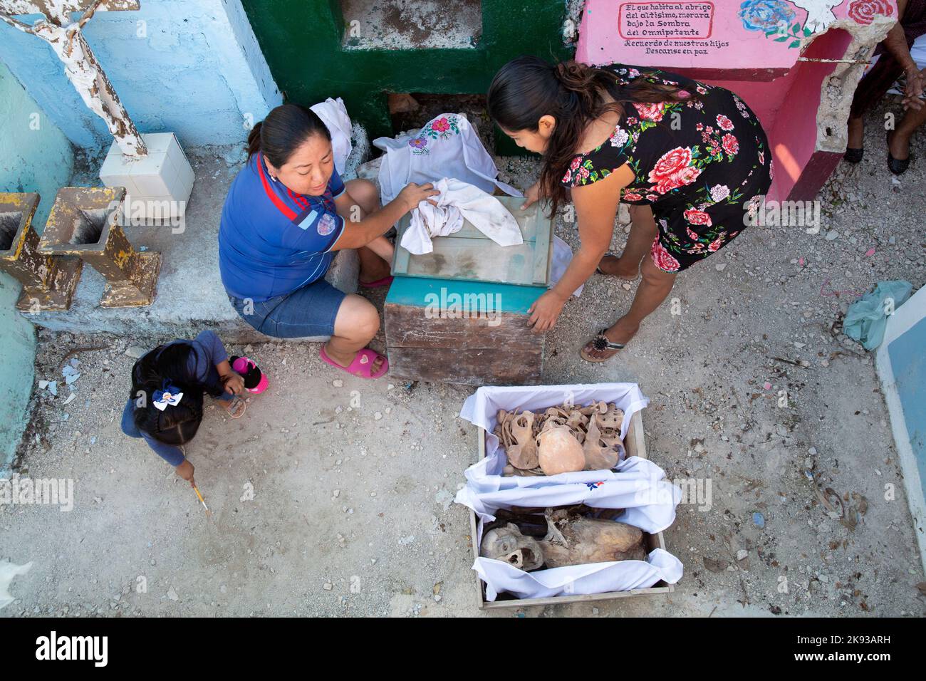Women clean the bones and skulls of their deceased relatives from the Kuk Pech family at the cemetery of Pomuch, Campeche state, Mexico on October 22, 2022. Every year in preparation for Hanal Pixán, the Mayan Day of the Dead celebration, members of the Pomuch community in southeastern Mexico extract bones from their niches and carefully clean them – an ancestral tradition seen as a gesture of love and a way to get closer to deceased family members. This ritual, which in Mayan is known as Choo Ba’ak, can be done for the first time when a person has been dead for three years. Pomuch and a handf Stock Photo