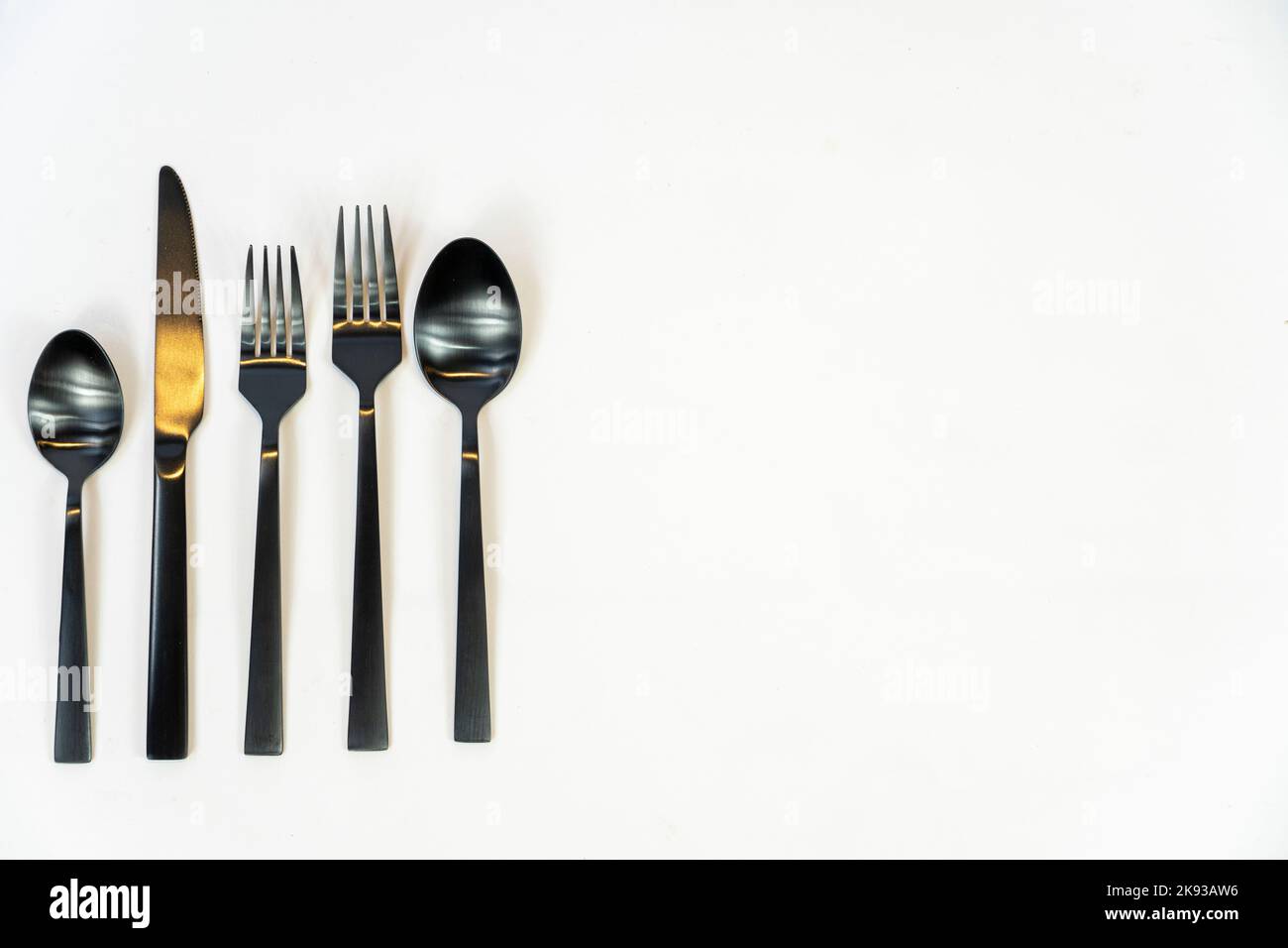 black metal Dinnerware Cutlery Utensils, Forks Knives, Spoons on Gray