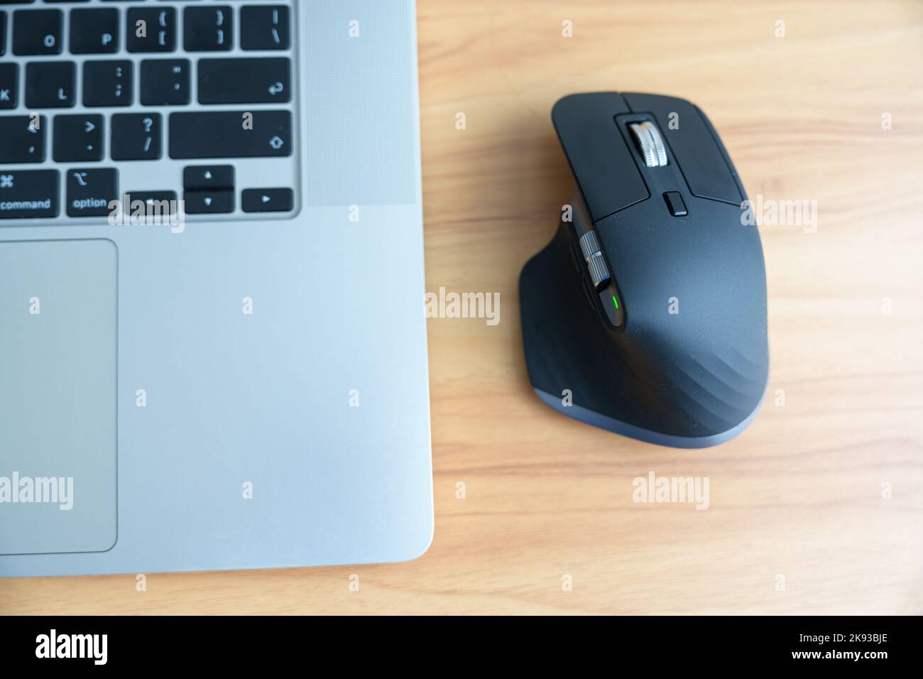 Ergonomic vertical mouse with laptop computer on adjustable desk at