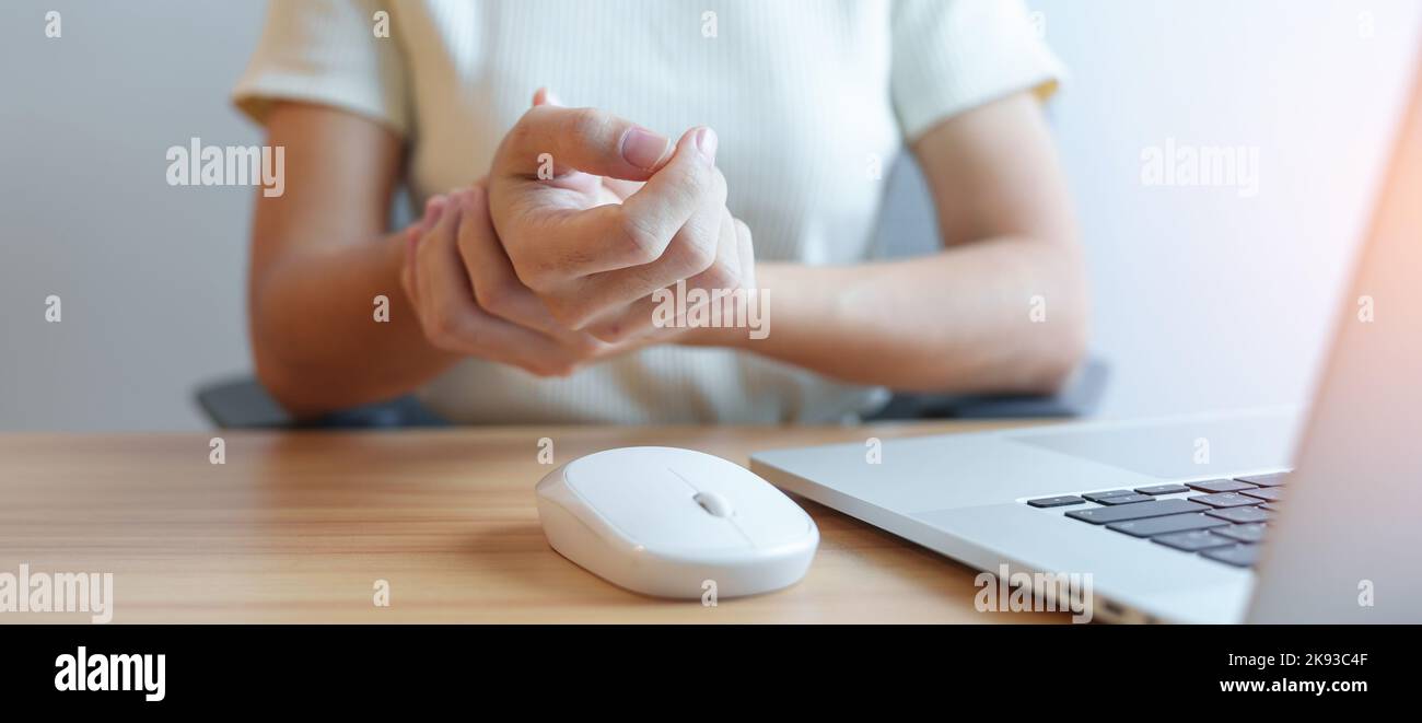 Woman having wrist pain when using mouse during working long time on workplace. De Quervain s