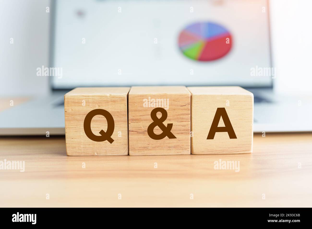 Questions and Ask wood block and laptop computer with graph background