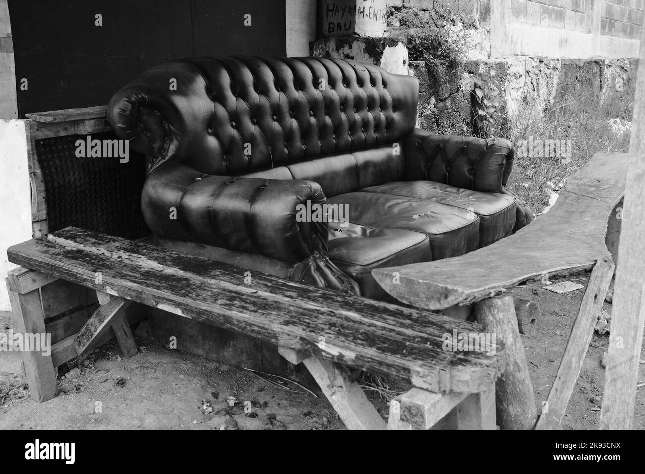 Black and white photo, Monochrome photo of a broken sofa on the side of