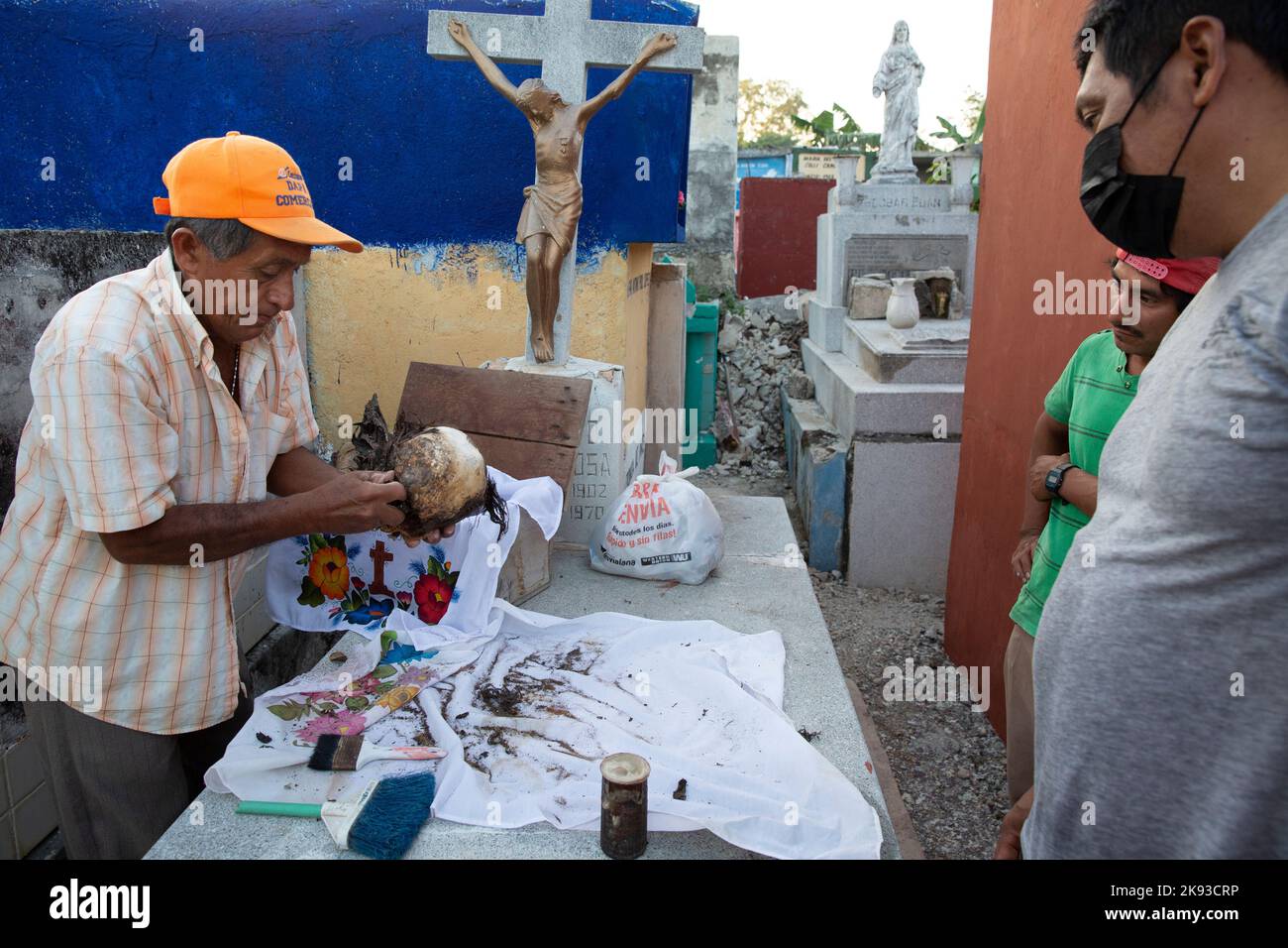Don Venancio Tuz Chi, one of the administrators of the Pomuch cemetery, cleaning the bones and skulls of a deceased relative of the Colli Ycauch family at the cemetery of Pomuch, Campeche state, Mexico on October 22, 2022. Don Venancio has been a hired bone cleaner for over twenty years, he is paid $1.50 per skeleton. Every year in preparation for Hanal Pixán, the Mayan Day of the Dead celebration, members of the Pomuch community in southeastern Mexico extract bones from their niches and carefully clean them – an ancestral tradition seen as a gesture of love and a way to get closer to deceased Stock Photo